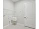 Bright laundry room featuring utility sink, shelving, and modern flooring at 12823 Daleridge Pl, Riverview, FL 33579