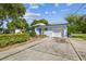 Ranch style home with a light blue exterior, landscaping, and driveway at 5101 W Platt St, Tampa, FL 33609