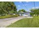 Light blue house with a white garage door, landscaping, and driveway at 5101 W Platt St, Tampa, FL 33609