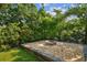 Charming fire pit area with stone border and lush landscaping at 5101 W Platt St, Tampa, FL 33609