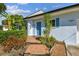 Welcoming light blue home with walkway, landscaping and tiled steps at 5101 W Platt St, Tampa, FL 33609