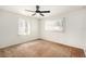 Bright bedroom with neutral carpet, white walls, ceiling fan, and windows with vertical blinds at 6611 14Th N St, St Petersburg, FL 33702