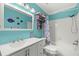 Bathroom with teal walls, shower/tub combo, and updated vanity at 104 Cypress Pond Rd, Palm Harbor, FL 34683