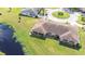 Aerial view of a cozy home with a well-maintained lawn and a serene pond, creating a peaceful and inviting atmosphere at 2104 Hembury Pl # 33, Sun City Center, FL 33573