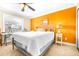 Bright bedroom with orange accent wall and a queen-size bed at 2104 Hembury Pl # 33, Sun City Center, FL 33573