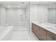 Bathroom with double vanity, wood cabinets, soaking tub, and glass enclosed shower at 301 1St S St # 1104, St Petersburg, FL 33701