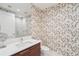 Stylish bathroom featuring floral wallpaper, wood vanity, and glass walk-in shower at 301 1St S St # 1104, St Petersburg, FL 33701