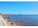 Picturesque waterfront scene with a wooden pier and a distant building by the water's edge on a clear day at 301 1St S St # 1104, St Petersburg, FL 33701