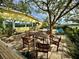 Relaxing backyard patio with wooden table and chairs under a large tree at 304 Patty Dr, Oldsmar, FL 34677