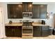 Modern kitchen with granite countertops and dark wood cabinets at 2117 Valterra Vista Way, Valrico, FL 33594