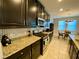 Modern kitchen with granite countertops and dark cabinets at 2117 Valterra Vista Way, Valrico, FL 33594