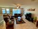 Open living room with brown couches and a large TV at 2117 Valterra Vista Way, Valrico, FL 33594