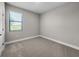 A carpeted bedroom with a large window, neutral paint, and white trim at 12152 Snow Bird Ave, Port Charlotte, FL 33981