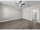 An open bedroom with hard wood floors features a ceiling fan and an ensuite bathroom at 12152 Snow Bird Ave, Port Charlotte, FL 33981