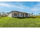 Exterior view of the home on a grass lawn, featuring black window frames at 12152 Snow Bird Ave, Port Charlotte, FL 33981