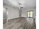 Large living room featuring plank flooring, neutral paint, a ceiling fan, and access to the backyard at 12152 Snow Bird Ave, Port Charlotte, FL 33981