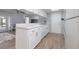 White kitchen cabinets and wood-look tile floor at 1875 Stetson Dr, Clearwater, FL 33765