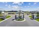 A grand entrance to the community featuring decorative gates, landscaping, and a clear view of the clubhouse at 3584 Maple Bay Ln, Land O Lakes, FL 34638