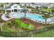 Aerial view of the community pool area showcasing the pool, lounge chairs, umbrellas, and lush landscaping at 3584 Maple Bay Ln, Land O Lakes, FL 34638