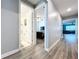 Bright hallway with light gray walls and wood-look flooring at 6119 Bradford Woods Dr, Zephyrhills, FL 33542