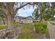 Side view of a single-story house with a two-car garage and mature trees at 2966 Brookfield Ln, Clearwater, FL 33761