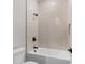 Clean, minimalist bathroom with a white tub, tiled walls, and black hardware at 5479 Brussels Ter, Port Charlotte, FL 33981