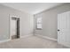 A cozy bedroom with neutral carpet, trim, and paint, complemented by natural light from the window at 5479 Brussels Ter, Port Charlotte, FL 33981