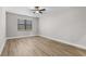 Well-lit bedroom with wood-look floors, a bright window, and simple decor at 5479 Brussels Ter, Port Charlotte, FL 33981