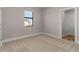 Neutral bedroom featuring carpet flooring, window overlooking yard and attached bathroom at 5479 Brussels Ter, Port Charlotte, FL 33981