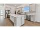 Modern kitchen with an island, stainless steel appliances, and light gray cabinets at 9457 Barnacle Ln, Parrish, FL 34219