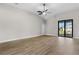 Bright and airy living room featuring wood floors, a ceiling fan, and sliding glass doors to the backyard at 12140 Warden Ave, Port Charlotte, FL 33981