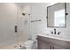 Modern bathroom with glass shower, white tile, and dark vanity at 4835 W San Jose St, Tampa, FL 33629