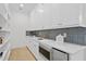 White kitchen butler's pantry with quartz countertops, blue tile backsplash, and ample shelving at 4835 W San Jose St, Tampa, FL 33629