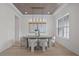 Bright dining room features a large chandelier and concrete table with light grey chairs at 4835 W San Jose St, Tampa, FL 33629