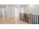 Light and bright hallway with hardwood floors and black metal railing at 4835 W San Jose St, Tampa, FL 33629