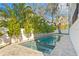 Inviting backyard pool with spa, surrounded by lush landscaping and elegant travertine tile at 4835 W San Jose St, Tampa, FL 33629