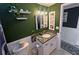 Modern bathroom with dark green walls, granite countertop, and updated vanity at 1619 Coppertree Dr, Tarpon Springs, FL 34689