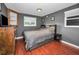 Bedroom with a gray color scheme, hardwood floors, and two windows for natural light at 1619 Coppertree Dr, Tarpon Springs, FL 34689