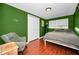 Bedroom with green walls, wood floors, and a comfortable bed at 1619 Coppertree Dr, Tarpon Springs, FL 34689