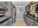 Galley kitchen features stainless steel appliances, granite countertops, and gray cabinetry at 1619 Coppertree Dr, Tarpon Springs, FL 34689