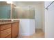 Bathroom with granite countertop, large shower, and light wood cabinets at 649 Chipper Dr, Sun City Center, FL 33573