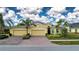 Two-story house with a three-car garage, landscaping, and brick driveway at 649 Chipper Dr, Sun City Center, FL 33573