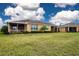 Back exterior view of single Gathering house with screened patio and landscaped yard at 649 Chipper Dr, Sun City Center, FL 33573