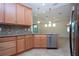 Kitchen features granite countertops, wood cabinets, and stainless steel dishwasher at 649 Chipper Dr, Sun City Center, FL 33573