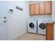 Laundry room with washer, dryer, and wood cabinets at 649 Chipper Dr, Sun City Center, FL 33573