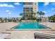 Community pool with surrounding lounge chairs and a high rise building in the background at 7625 Sun Island S Dr # 101, South Pasadena, FL 33707