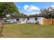 Newly renovated mid-century home with white exterior, fenced yard, and driveway at 8816 Ashman Rd, Riverview, FL 33578