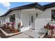 Updated mid-century home with white brick exterior, landscaping, and a modern front door at 8816 Ashman Rd, Riverview, FL 33578