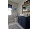 Spa-like bathroom with navy vanity, shiplap walls, and patterned tile at 5476 Oakridge Dr, Palm Harbor, FL 34685