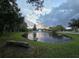 Serene pond with fountain at sunset, neighborhood view at 5476 Oakridge Dr, Palm Harbor, FL 34685